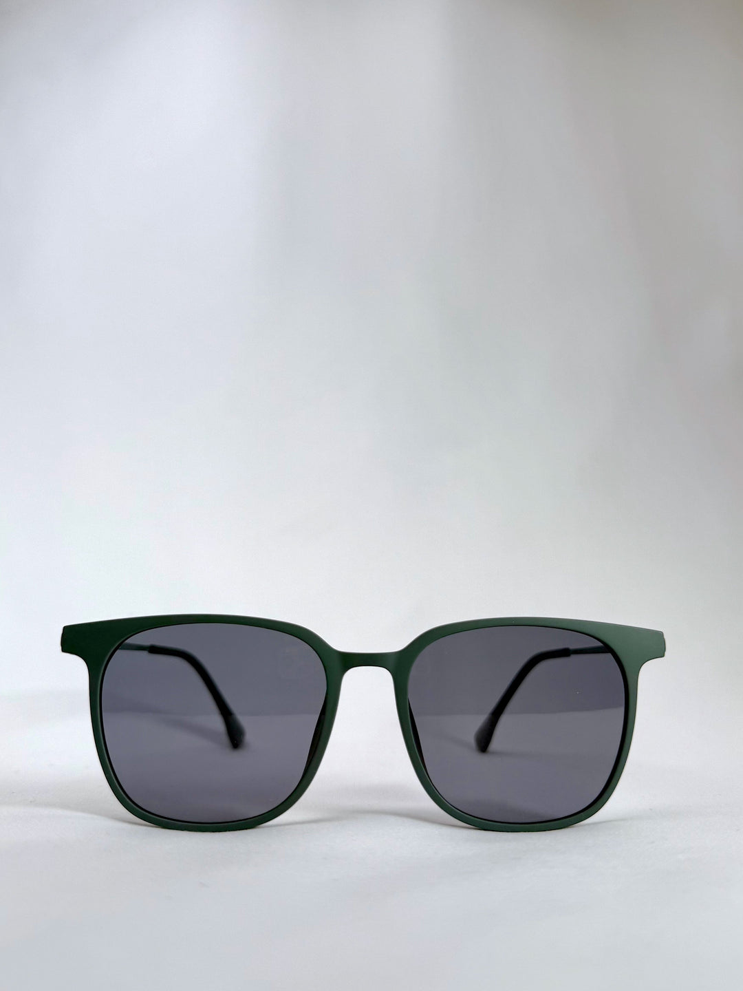 Front view of Achernar deep matte green titanium sunglasses with UV400 polarized lenses, offering a modern and refined look.