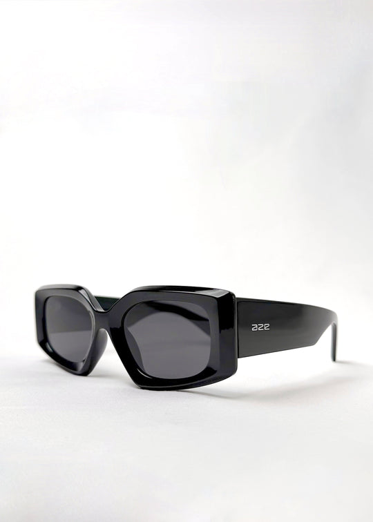 Angled view of Bellatrix black acetate sunglasses featuring a bold oversized frame with high-gloss finish and UV400 polarized lenses.