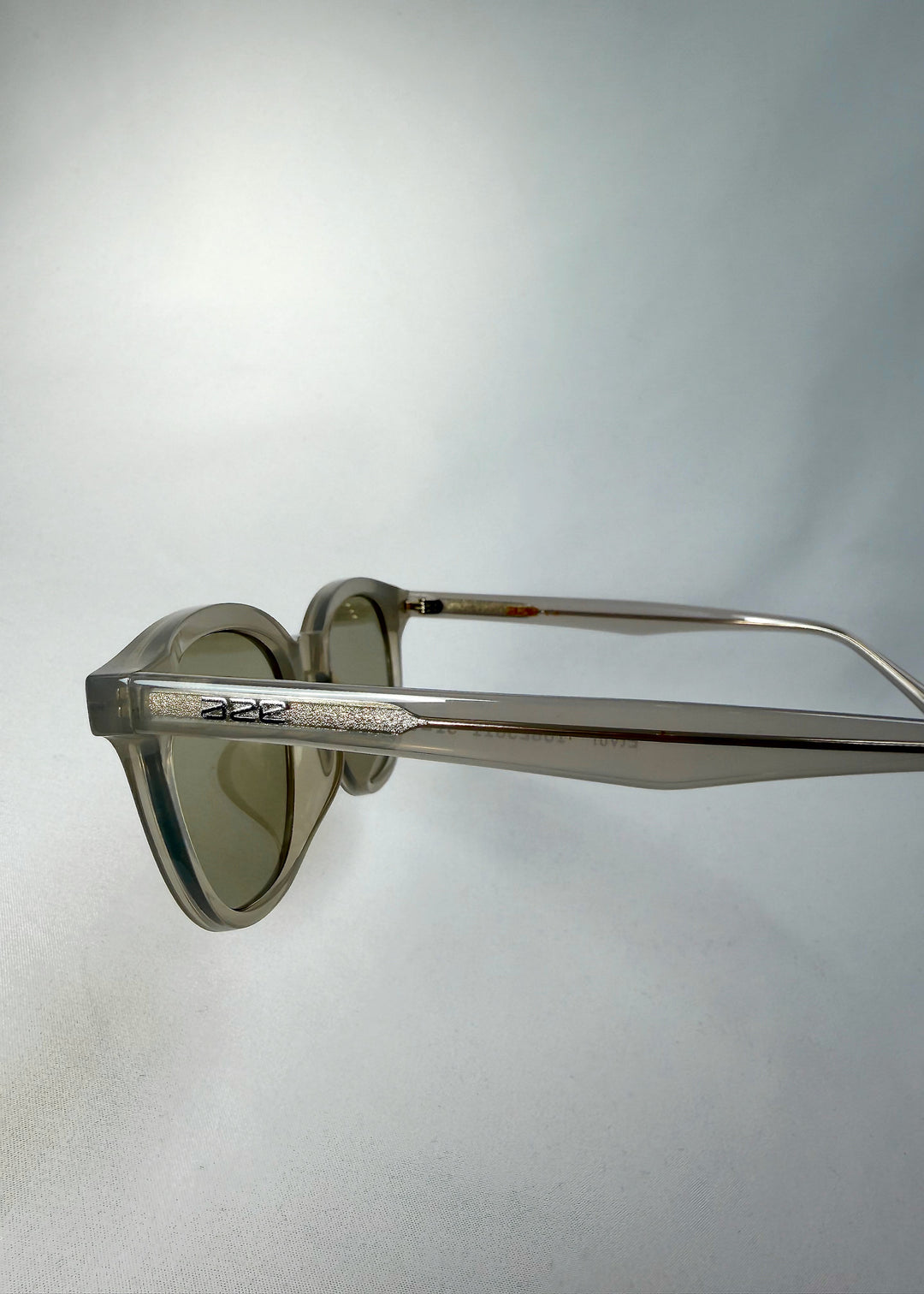 Side temple detail of Elvor sunglasses in Glacier Smoke, showing frosted acetate frame and hinge design.
