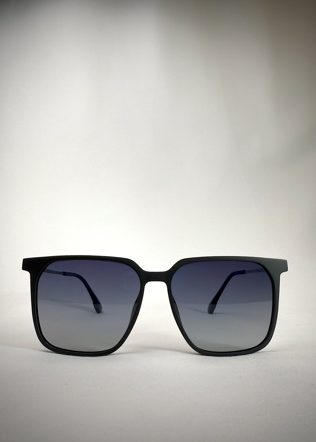 Front view of Gemini Matte Blue titanium sunglasses, showcasing the sleek square frame and deep blue finish.