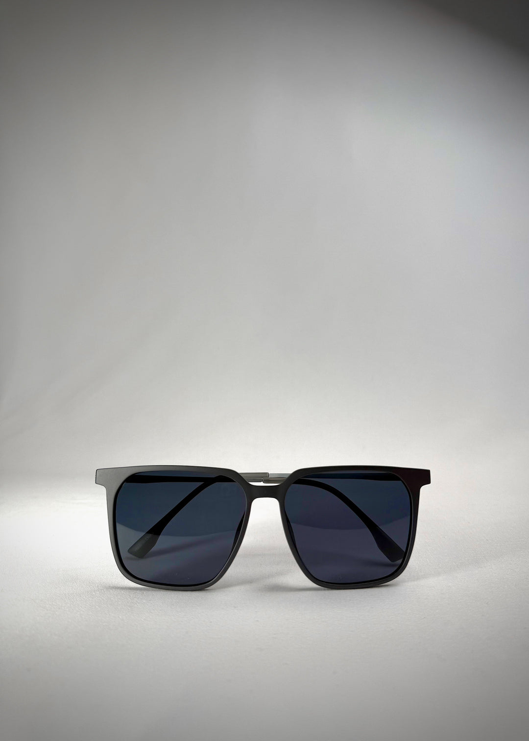 Folded-arm front view of Gemini Matte Gray titanium sunglasses, emphasizing the beautiful lenses and sleek frame.