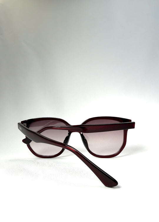 Folded view of Lucent Rift in Velvet Eclipse with arms crossed over the gradient plum lenses.