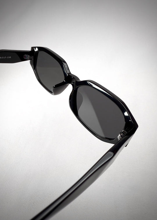 Angled view of Lyra black acetate sunglasses – highlighting sharp frame lines and glossy finish.