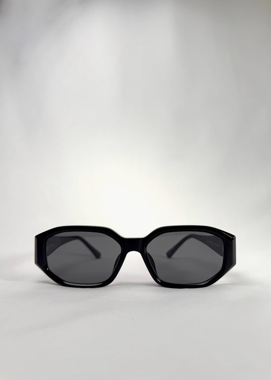 Front view of Lyra glossy black acetate sunglasses – bold angular frame with classic gray lenses.