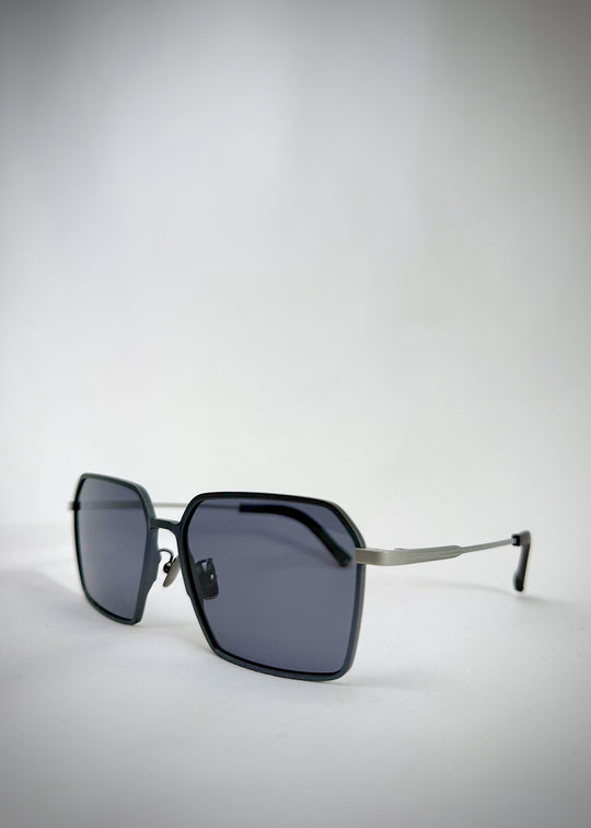 Side-angle view of Rigel matte gray titanium sunglasses featuring a bold geometric frame, lightweight construction, and sleek polarized lenses.