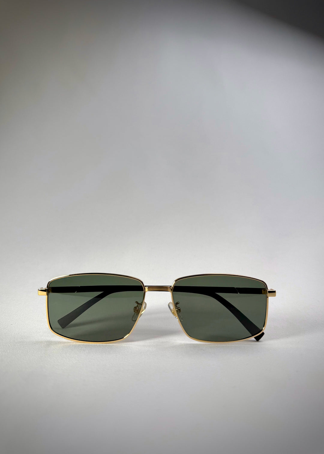 Folded front view of Sirius A - Gold stainless steel sunglasses featuring a sleek gold frame and polarized green lenses for a refined, modern look.