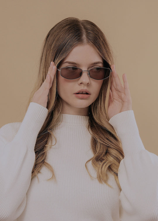 Female model wearing Sirius B Gunmetal Amber sunglasses – Elegant and versatile prescription eyewear.