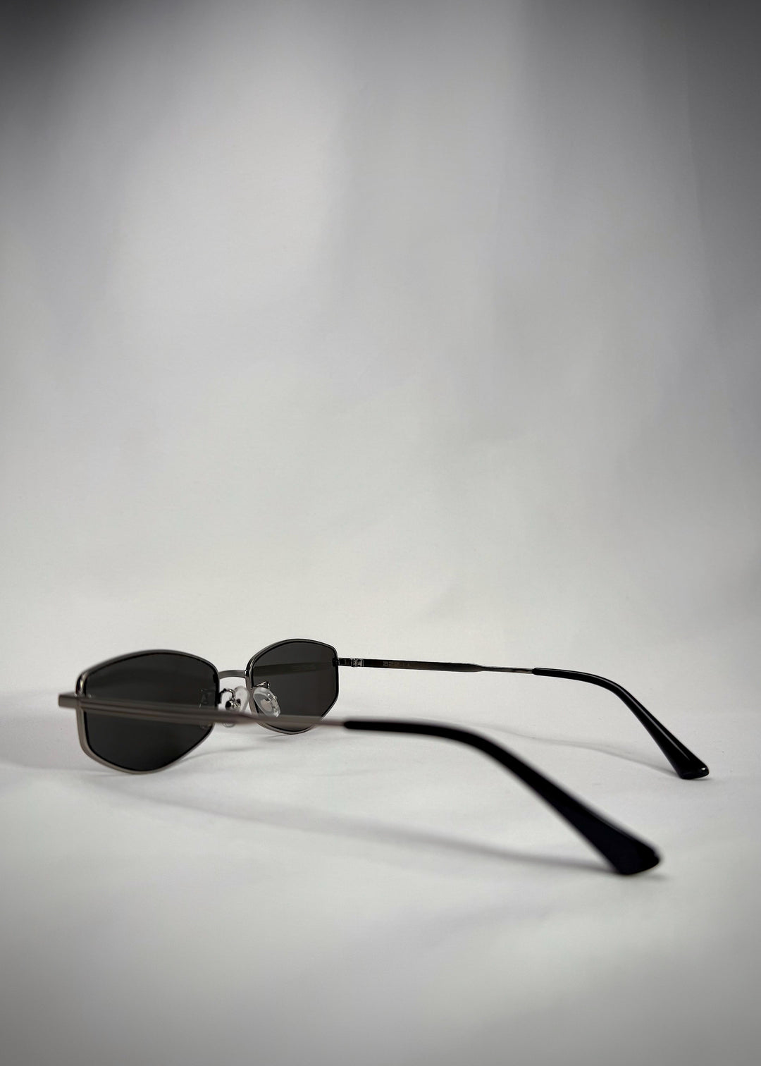 Side angle of Sirius B Gunmetal sunglasses, showcasing the sleek stainless steel frame and premium green lenses.