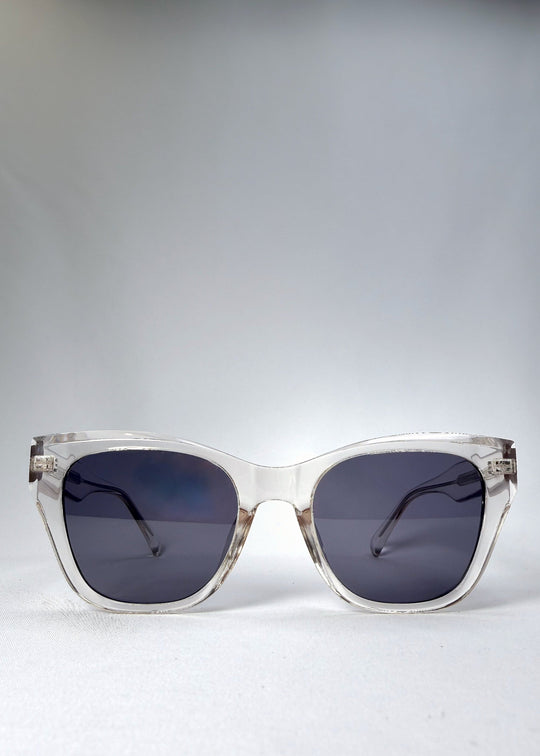 Front view of the Veyron sunglasses in Crystal Static, featuring a bold clear acetate frame with clean lines and slate-blue lenses.