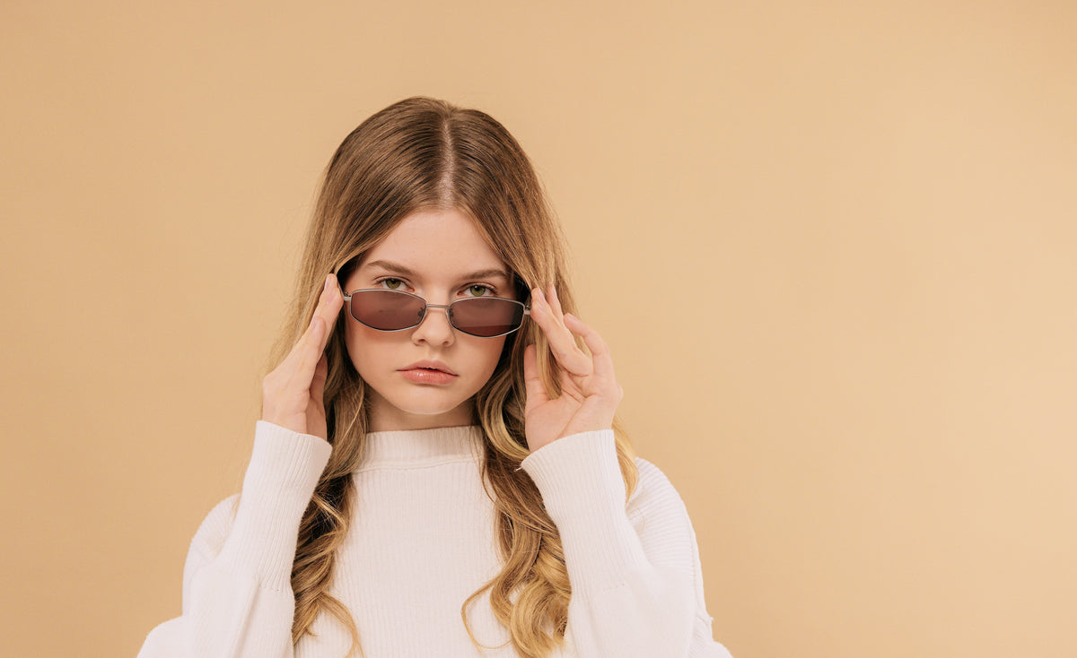 Model wearing AZE sunglasses against a warm beige backdrop