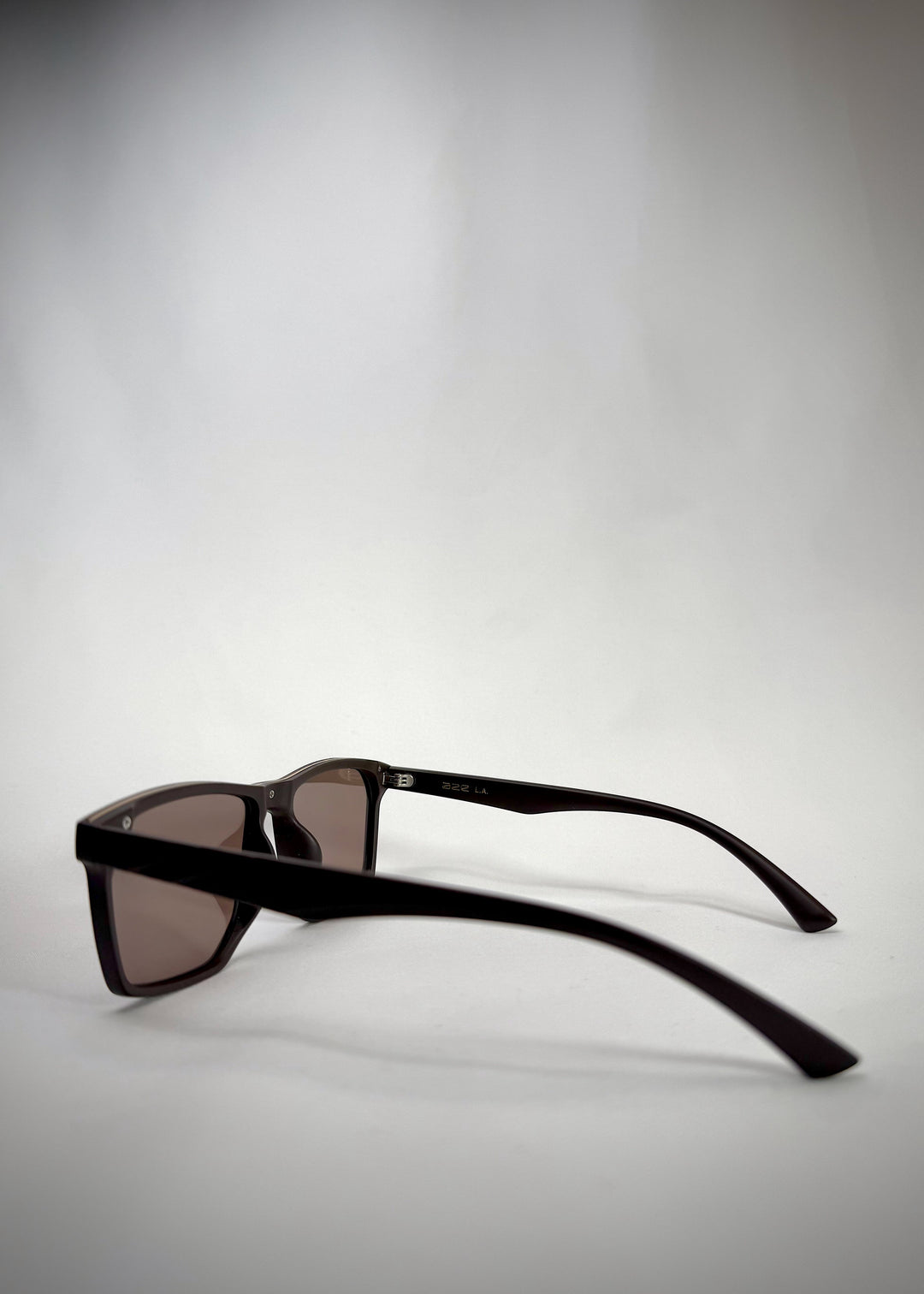 Rear three-quarter view of Betelgeuse matte brown TR90 sunglasses, showing the slim acetate temple and matte frame finish. 
