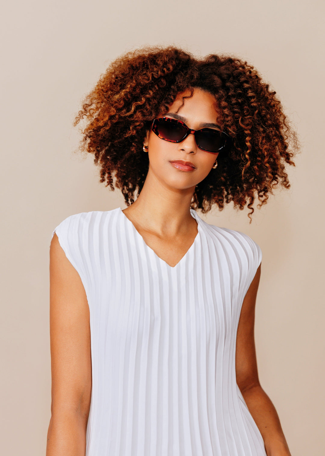 Female model wearing Castor sunglasses in Tortoiseshell with a white sleeveless top. 