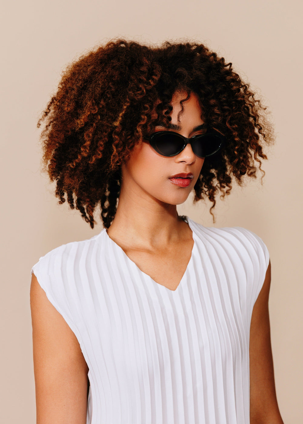 Model wearing Dagger sunglasses in Obsidian Black with a white sleeveless top, shown in a three-quarter portrait.