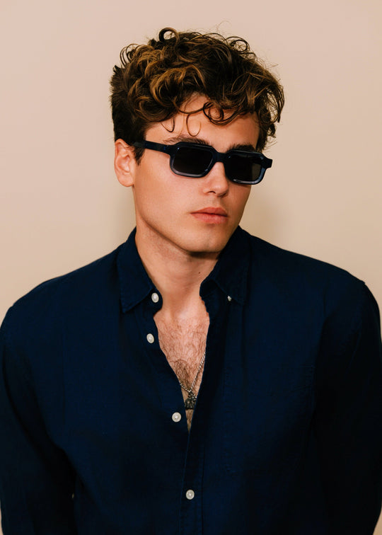 Model wearing Havoc sunglasses in Abyss Azure facing forward, showing how the bold rectangular frame sits across the face. 