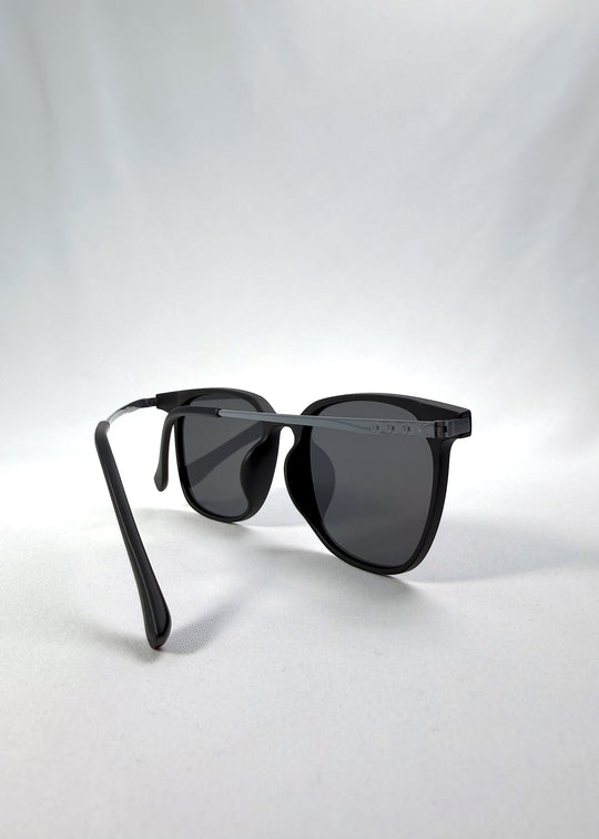 Back-angle view of Achernar sunglasses in Classic Black, featuring ultra-light titanium frame, softly geometric lens shape, and polarized lenses, showing the back structure and temple alignment.