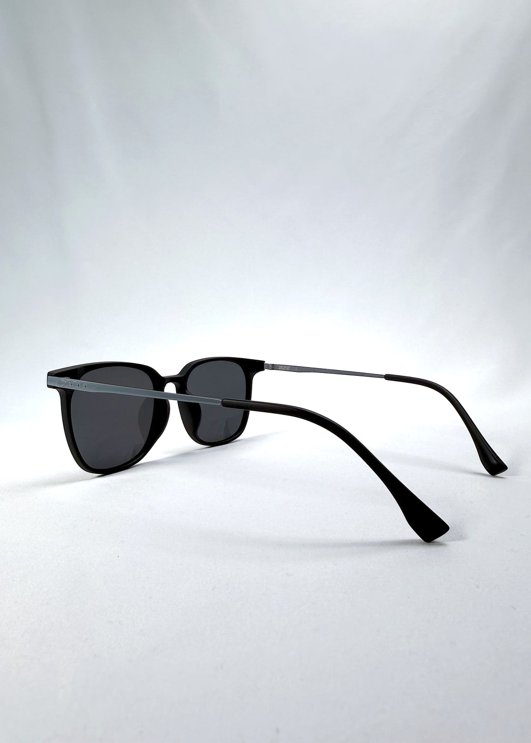 Side-angle view of Achernar sunglasses in Classic Black, featuring ultra-light titanium frame, softly geometric lens shape, and polarized lenses, showing the lens shape and temple profile.