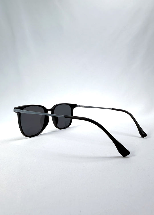 Side-angle view of Achernar sunglasses in Classic Black, featuring ultra-light titanium frame, softly geometric lens shape, and polarized lenses, showing the lens shape and temple profile.