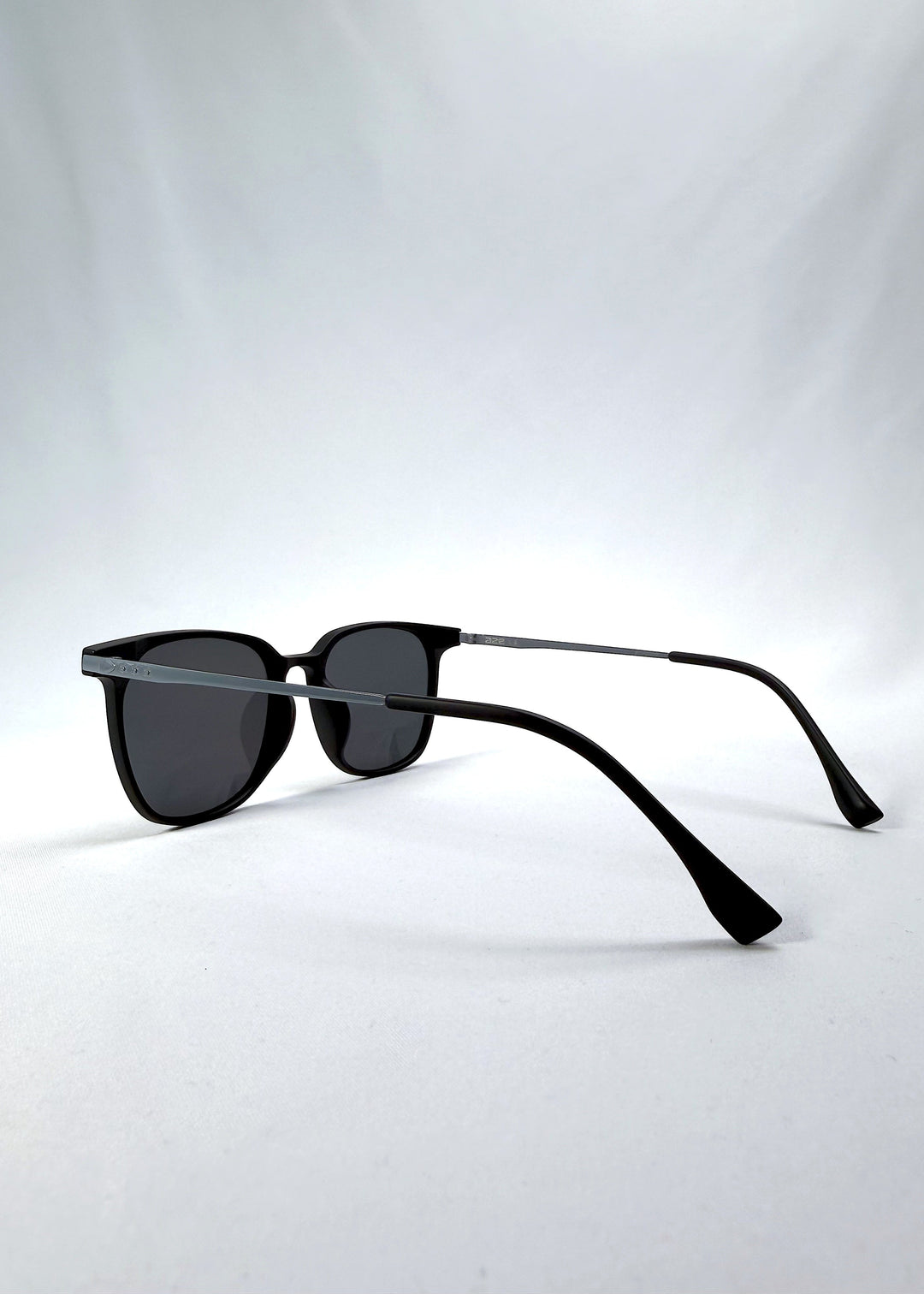 Side-angle view of Achernar sunglasses in Classic Black, featuring an ultra-light frame with titanium temples, softly geometric lens shape, and polarized lenses, showing the lens shape and temple profile. 