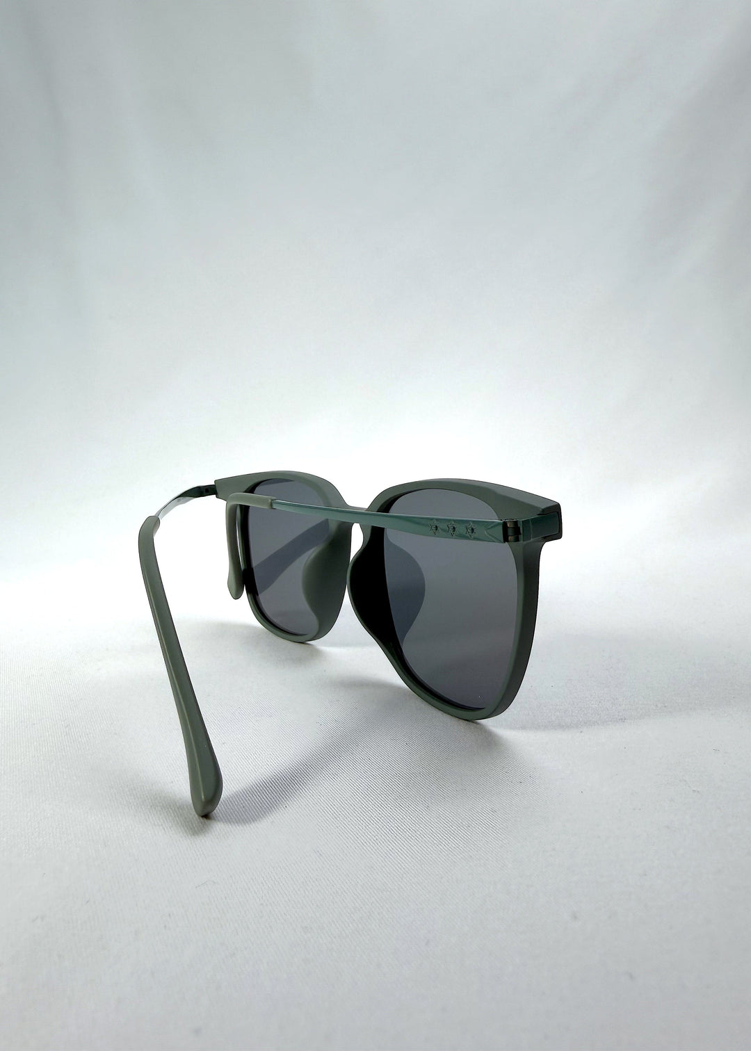 Back-angle view of Achernar sunglasses in Deep Matte Green, featuring an ultra-light frame with titanium temples, softly geometric lens shape, and polarized lenses, showing the back structure and temple alignment. 