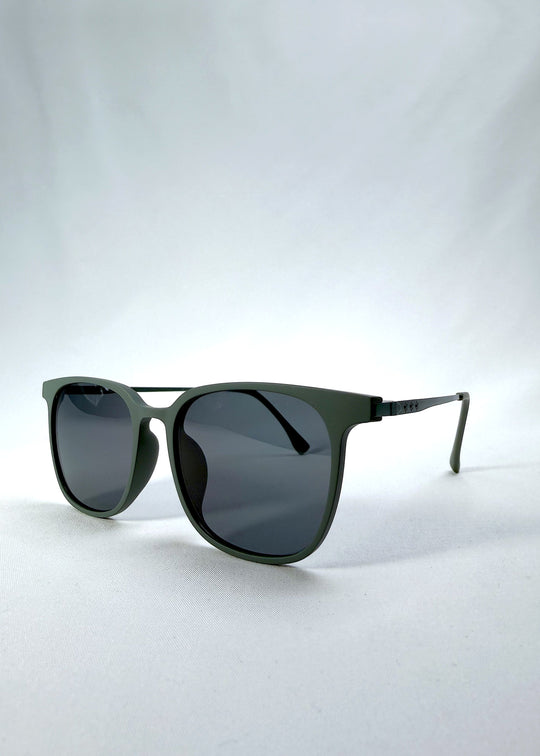 Three-quarter front view of Achernar sunglasses in Deep Matte Green, featuring an ultra-light frame with titanium temples, softly geometric lens shape, and polarized lenses, showing the front shape and temple profile. 