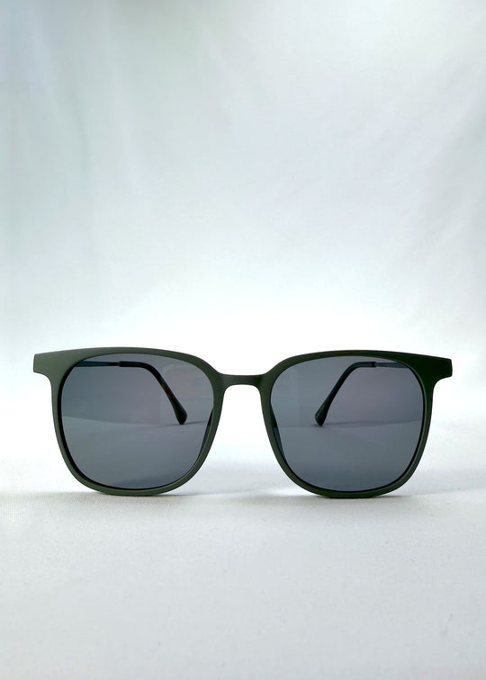Front view of Achernar sunglasses in Deep Matte Green, featuring an ultra-light frame with titanium temples, softly geometric lens shape, and polarized lenses, showing the full front silhouette. 