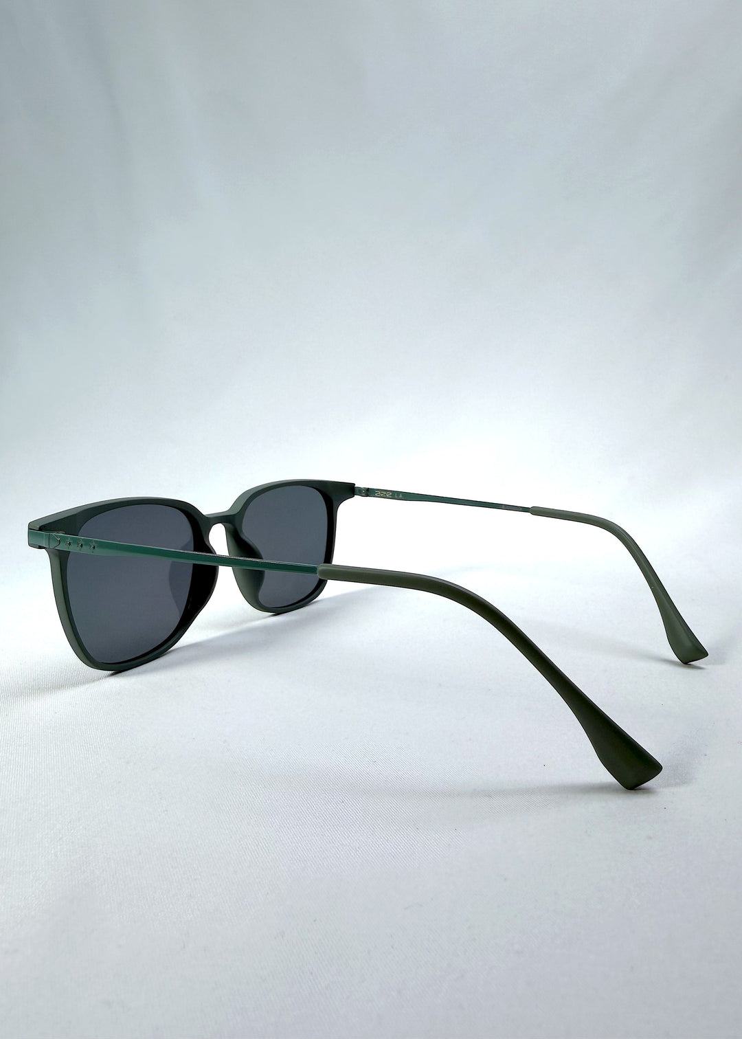 Side-angle view of Achernar sunglasses in Deep Matte Green, featuring an ultra-light frame with titanium temples, softly geometric lens shape, and polarized lenses, showing the lens shape and temple profile. 