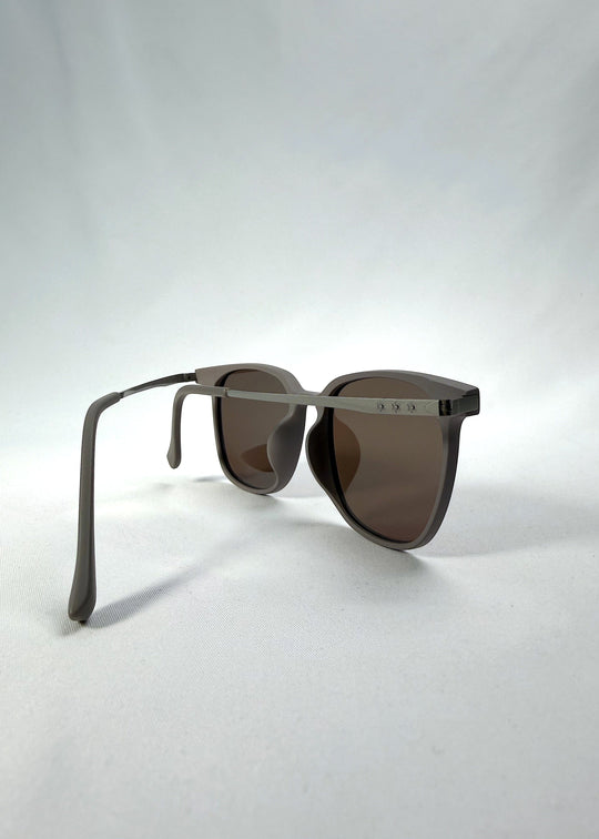 Back-angle view of Achernar sunglasses in Khaki Brown, featuring an ultra-light frame with titanium temples, softly geometric lens shape, and polarized lenses, showing the back structure and temple alignment. 