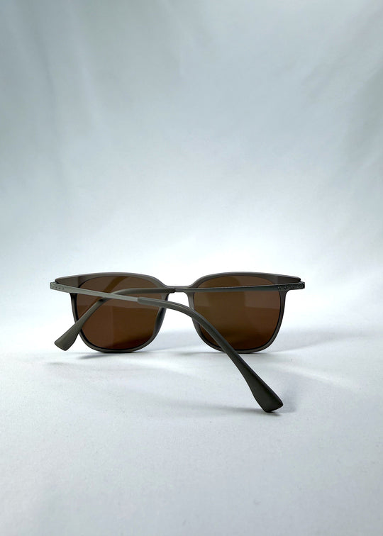 Folded view of Achernar sunglasses in Khaki Brown, featuring an ultra-light frame with titanium temples, softly geometric lens shape, and polarized lenses, showing the folded temples and frame profile. 