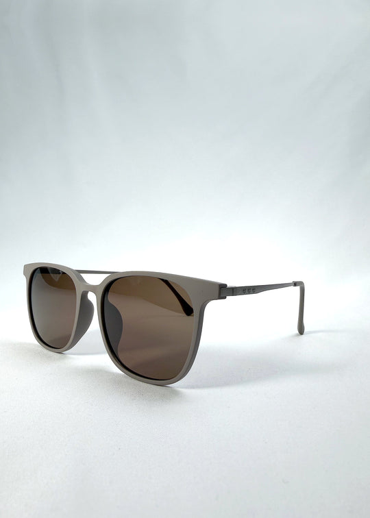 Three-quarter front view of Achernar sunglasses in Khaki Brown, featuring an ultra-light frame with titanium temples, softly geometric lens shape, and polarized lenses, showing the front shape and temple profile. 