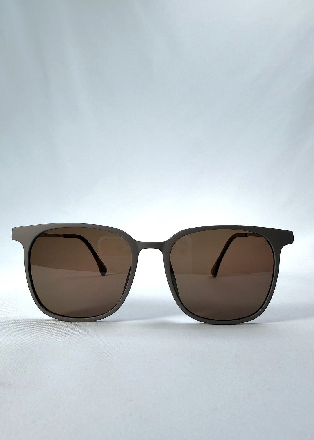 Front view of Achernar sunglasses in Khaki Brown, featuring an ultra-light frame with titanium temples, softly geometric lens shape, and polarized lenses, showing the full front silhouette. 