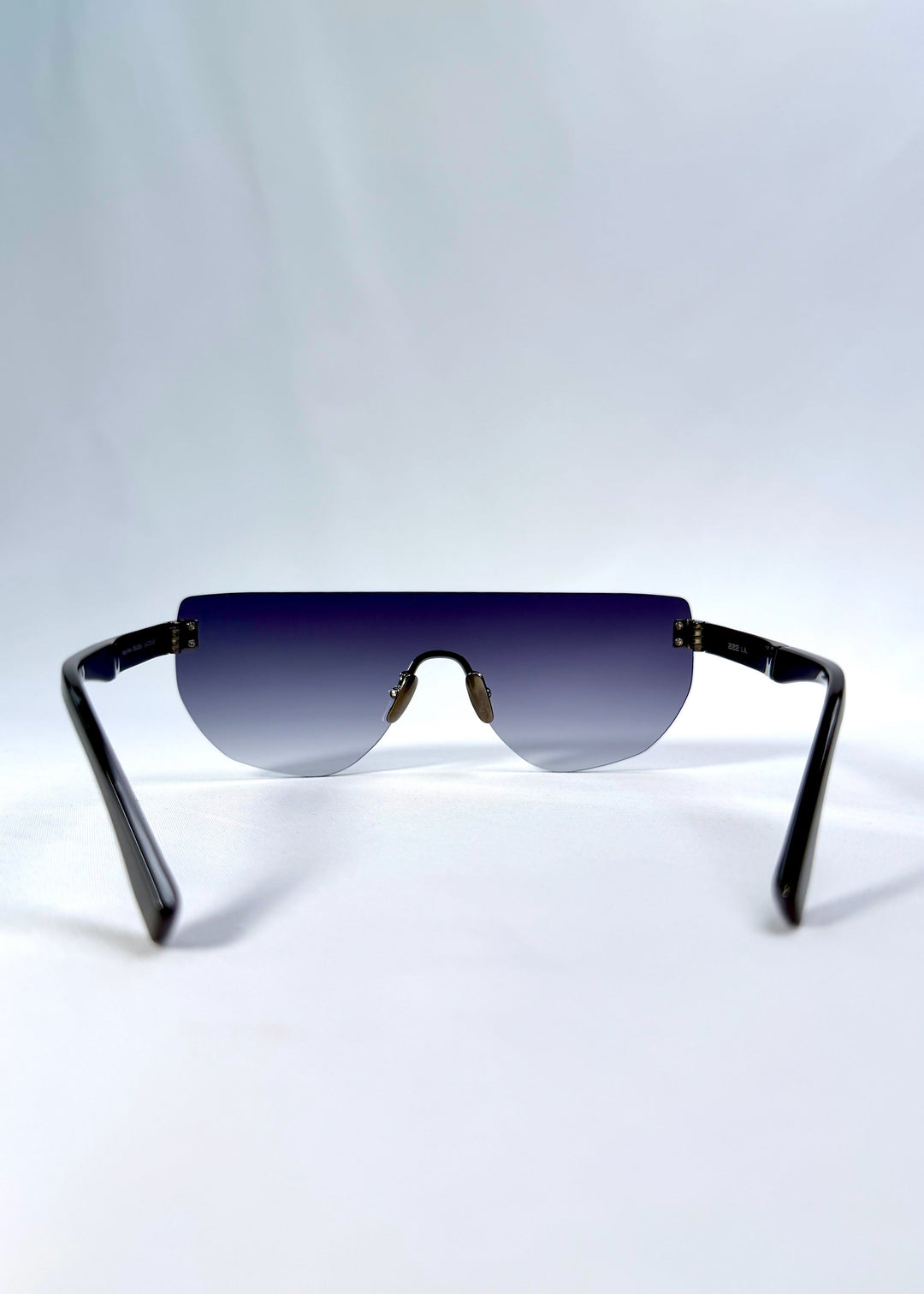 Back view of Aegis Field sunglasses in Gunmetal Veil, featuring one-piece titanium shield frame and gunmetal-to-grey gradient lens, showing the inside frame and open temples. 