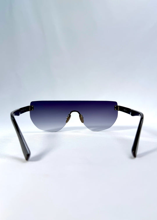 Back view of Aegis Field sunglasses in Gunmetal Veil, featuring one-piece titanium shield frame and gunmetal-to-grey gradient lens, showing the inside frame and open temples. 