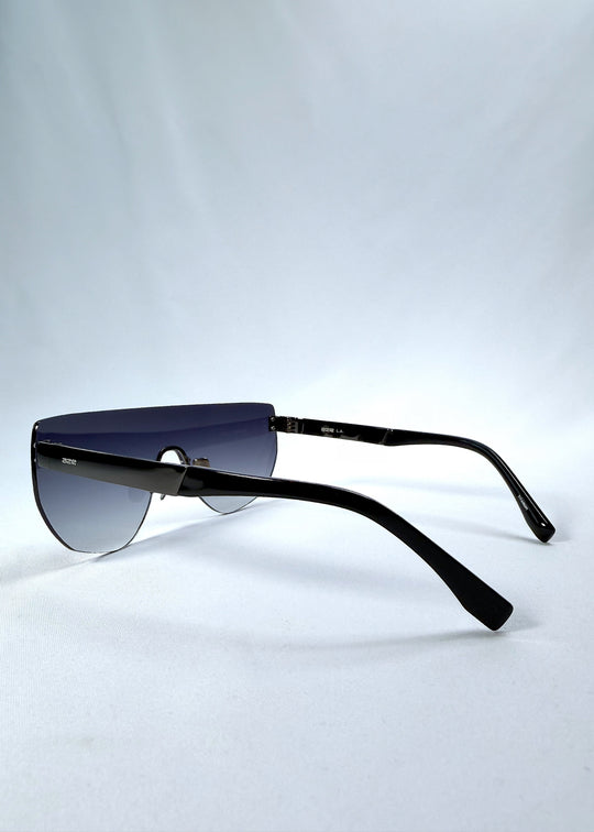 Side view of Aegis Field sunglasses in Gunmetal Veil, featuring one-piece titanium shield frame and gunmetal-to-grey gradient lens, showing the lens shape and temple profile.