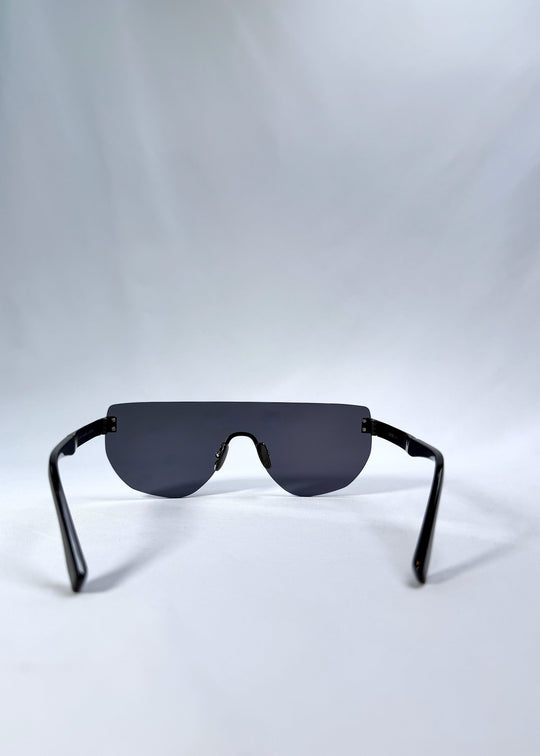 Back view of Aegis Field sunglasses in Mercury Shadow, featuring one-piece titanium shield frame and silver mirrored lens, showing the inside frame and open temples. 