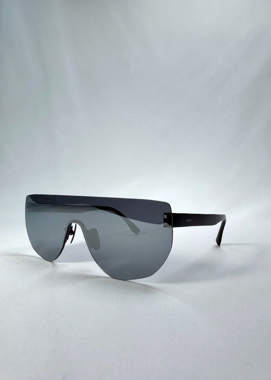 Three-quarter front view of Aegis Field sunglasses in Mercury Shadow, featuring one-piece titanium shield frame and silver mirrored lens, showing the front shape and temple profile. 