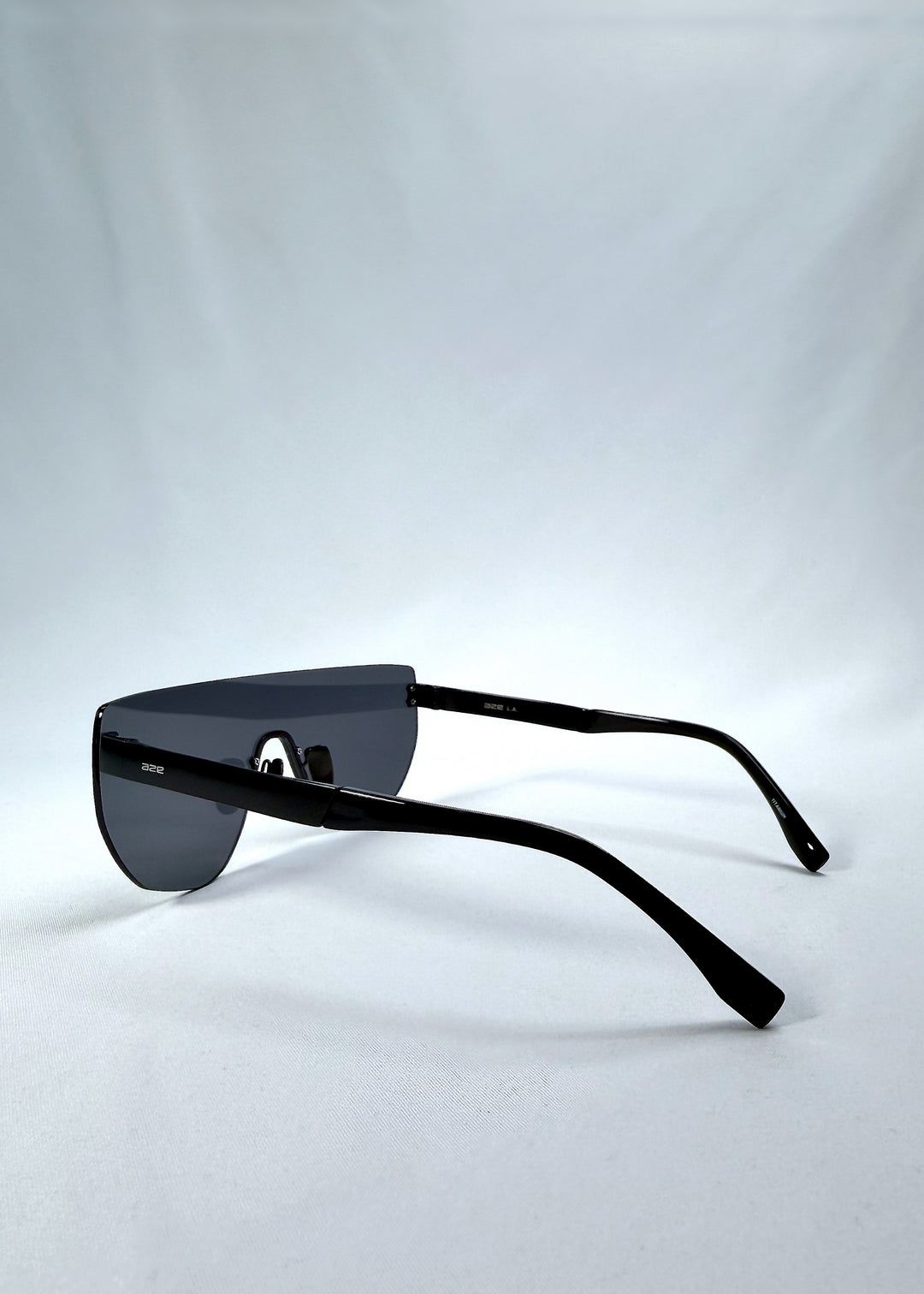 Side view of Aegis Field sunglasses in Mercury Shadow, featuring one-piece titanium shield frame and silver mirrored lens, showing the lens shape and temple profile.