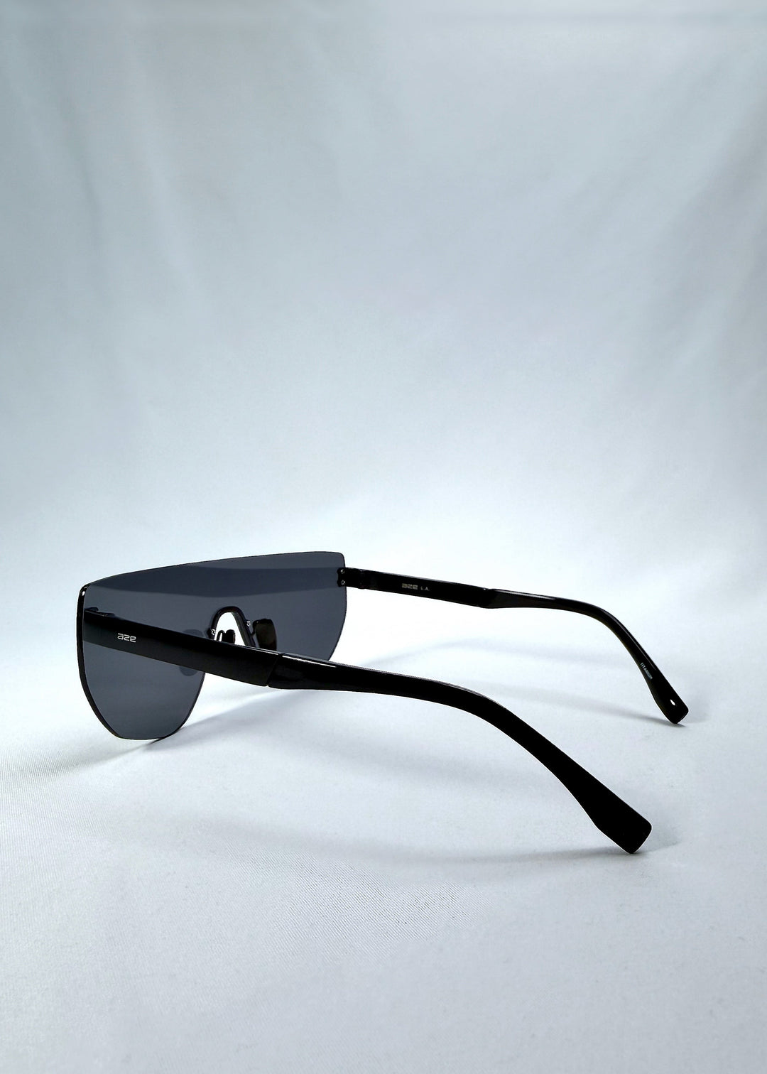 Side view of Aegis Field sunglasses in Mercury Shadow, featuring one-piece titanium shield frame and silver mirrored lens, showing the lens shape and temple profile. 