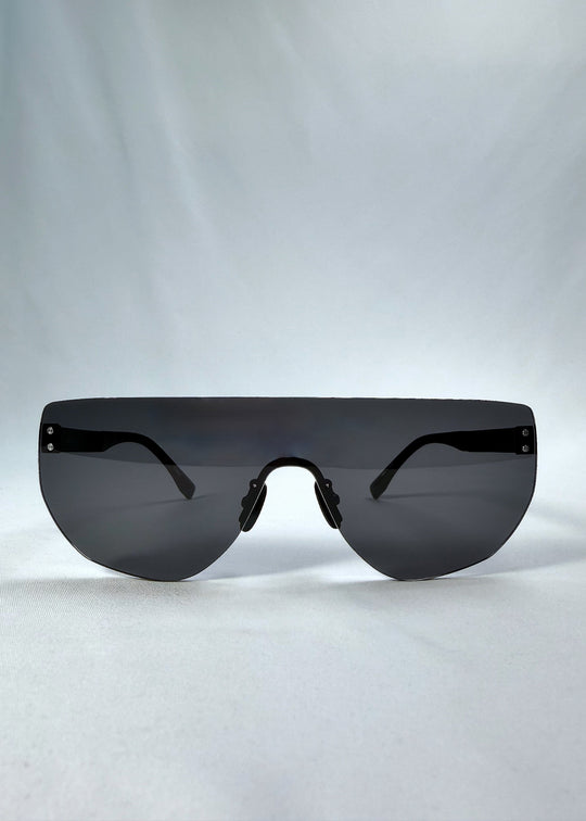 Front view of Aegis Field sunglasses in Obsidian Black, featuring one-piece titanium shield frame and smoky black lens, showing the full front silhouette. 
