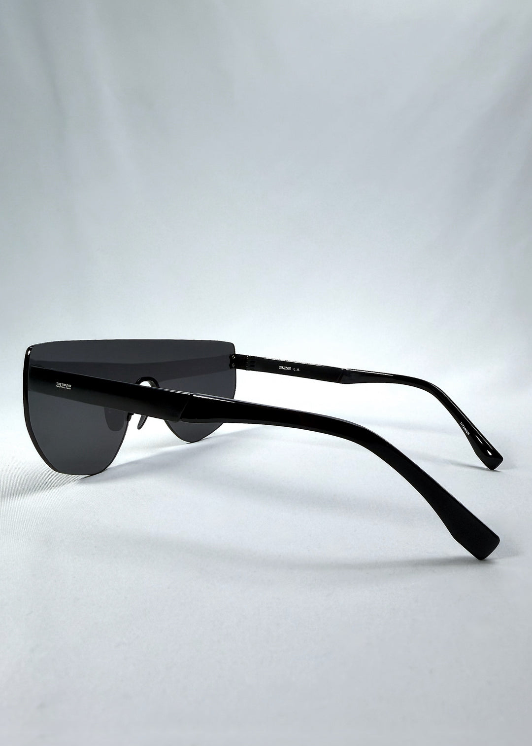 Side view of Aegis Field sunglasses in Obsidian Black, featuring one-piece titanium shield frame and smoky black lens, showing the lens shape and temple profile.