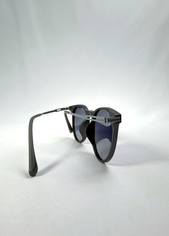 Back-angle view of Altair sunglasses in Matte Gray, featuring minimal titanium frame, rounded square lens shape, and polarized lenses, showing the back structure and temple alignment.