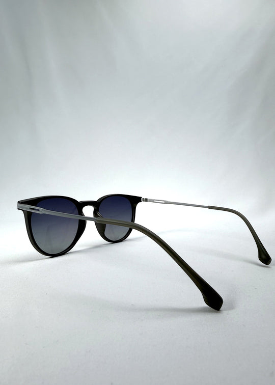 Side-angle view of Altair sunglasses in Matte Gray, featuring a minimal frame with titanium temples, rounded square lens shape, and polarized lenses, showing the lens shape and temple profile. 