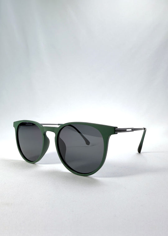Three-quarter front view of Altair sunglasses in Matte Green, featuring minimal titanium frame, rounded square lens shape, and polarized lenses, showing the front shape and temple profile.