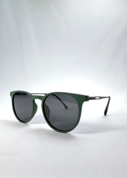 Three-quarter front view of Altair sunglasses in Matte Green, featuring a minimal frame with titanium temples, rounded square lens shape, and polarized lenses, showing the front shape and temple profile. 