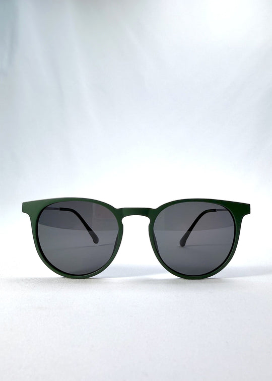 Front view of Altair sunglasses in Matte Green, featuring a minimal frame with titanium temples, rounded square lens shape, and polarized lenses, showing the full front silhouette. 