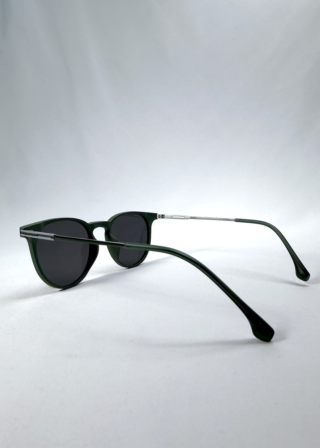 Side-angle view of Altair sunglasses in Matte Green, featuring a minimal frame with titanium temples, rounded square lens shape, and polarized lenses, showing the lens shape and temple profile. 