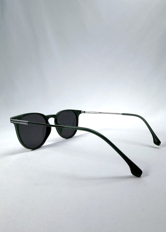 Side-angle view of Altair sunglasses in Matte Green, featuring a minimal frame with titanium temples, rounded square lens shape, and polarized lenses, showing the lens shape and temple profile. 