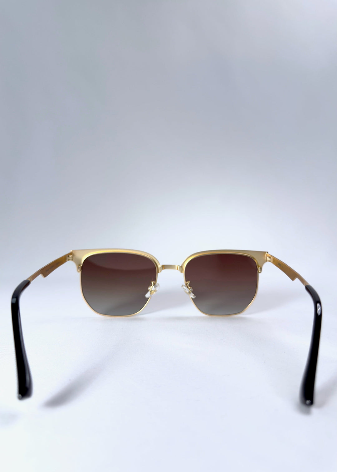 Back view of Altessa sunglasses highlighting the adjustable nose pads and golden metal frame structure. 