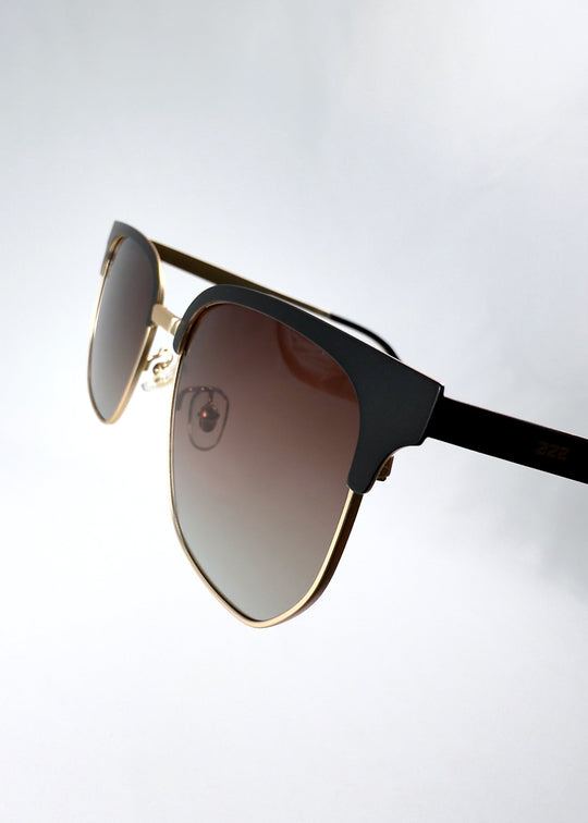 Frame closeup of Altessa sunglasses in Antique Brass showing the browline construction and smooth metal finish. 