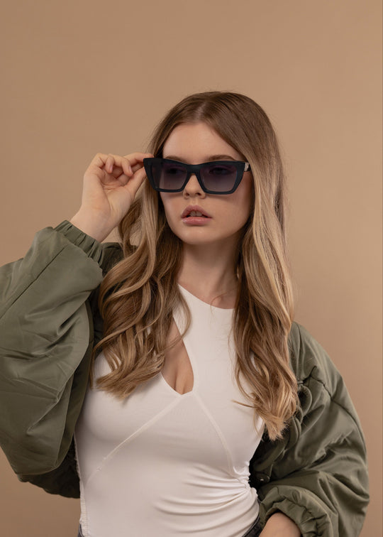 Female model wearing Aquila Blue prescription sunglasses, styled for a bold everyday look. 