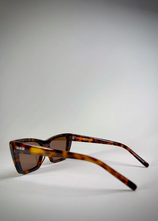Side angle of Aquila Tortoiseshell sunglasses, showing the structured acetate frame and warm amber tones. 